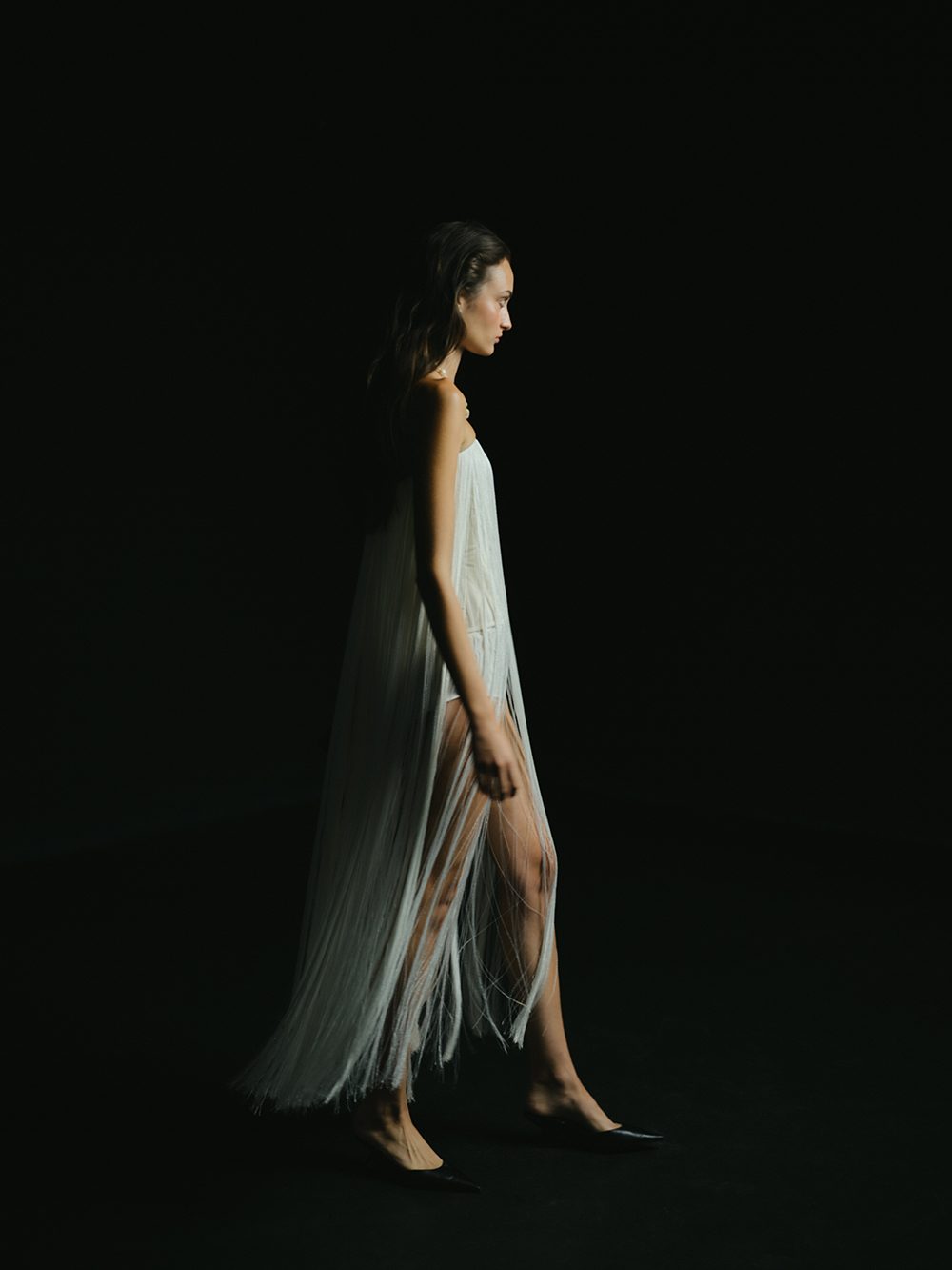 The After: long fringe dress in profile, in darkness