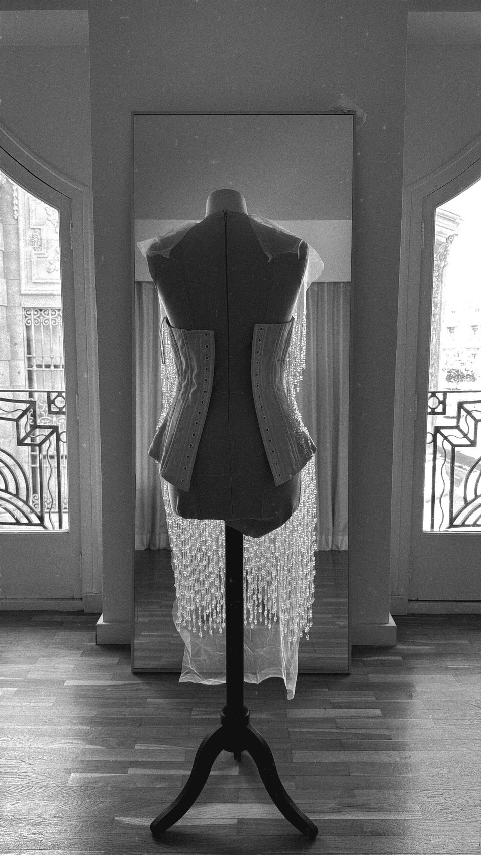 A corset with crystal fringe on the form, between the windows of the WOMANZE studio