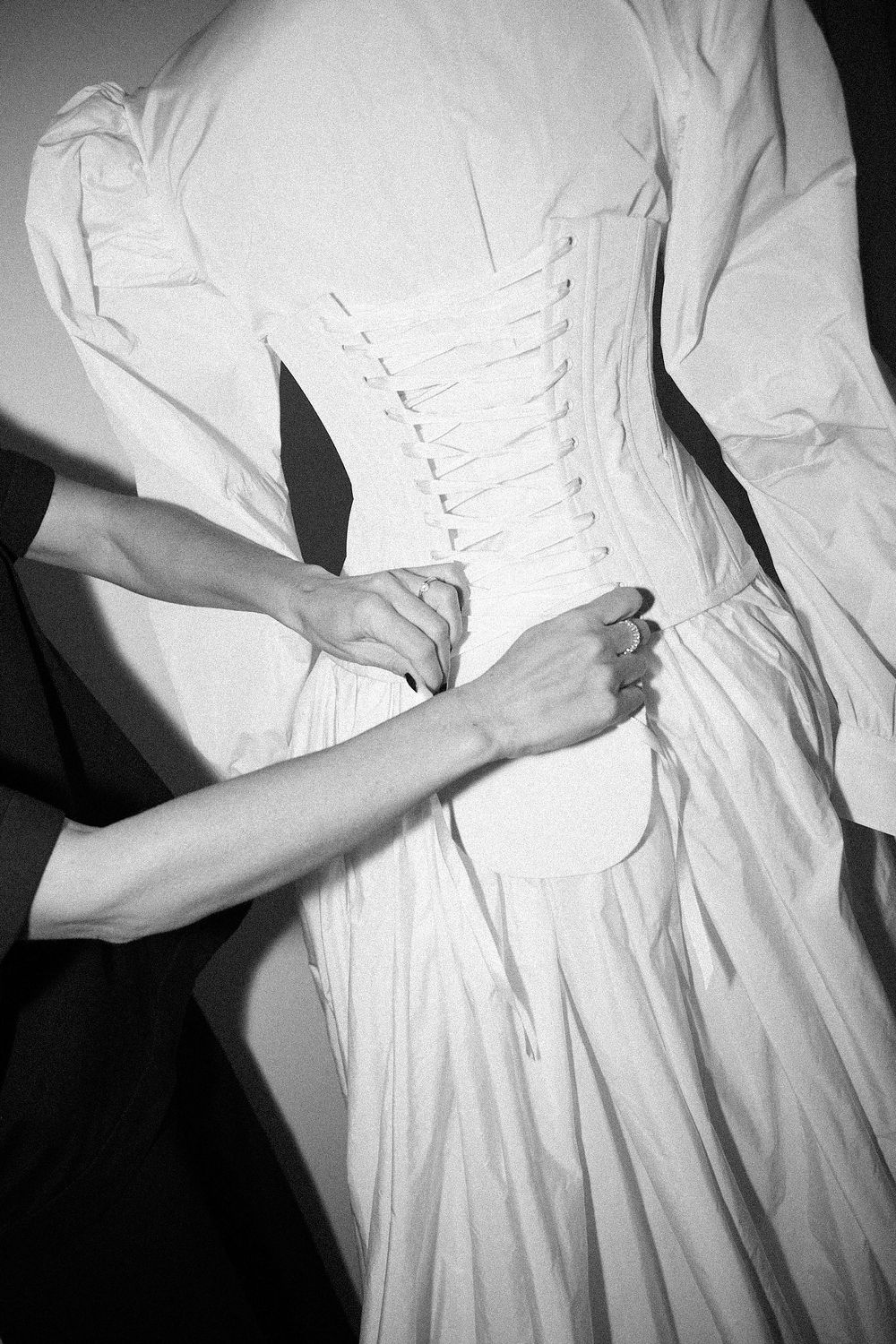 Hands lacing a corset on the form, WOMANZE atelier, Valencia